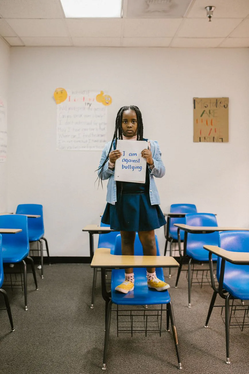 A child holding an anti-bullying sign in a classroom, promoting awareness
