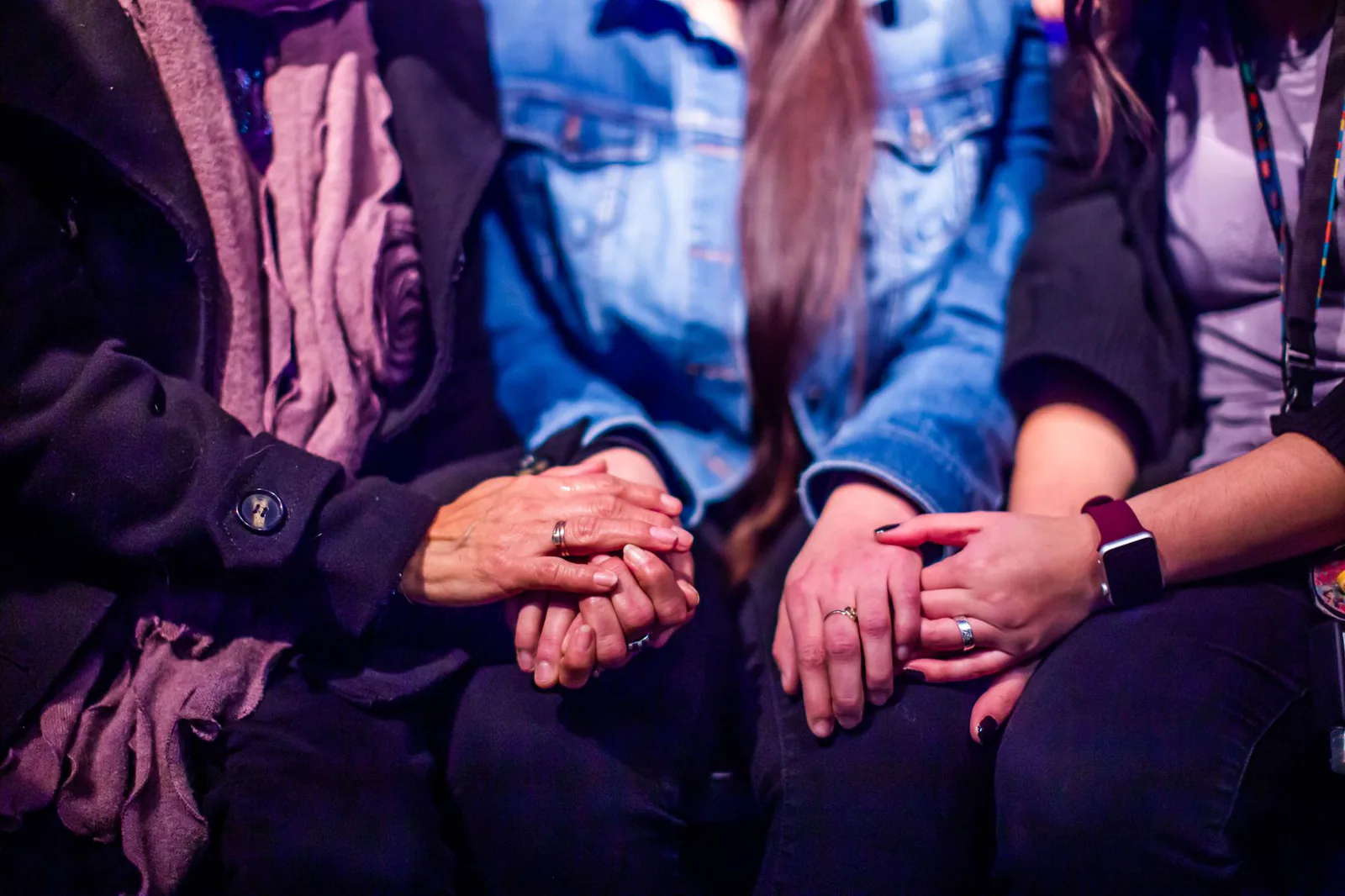 Women holding hands in a circle, symbolizing solidarity and mutual support